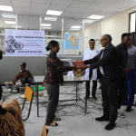 Official handover of books between representatives and donated computers/cabinets